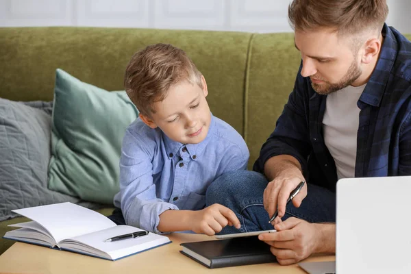 Fader att hjälpa sin son att göra lektioner hemma — Stockfoto