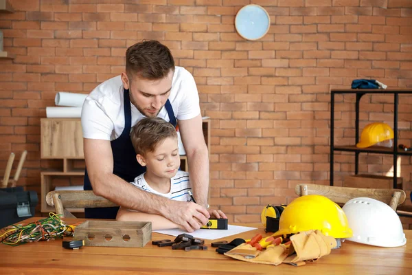 Padre enseñando a su pequeño hijo a manejar con herramientas en casa — Foto de Stock