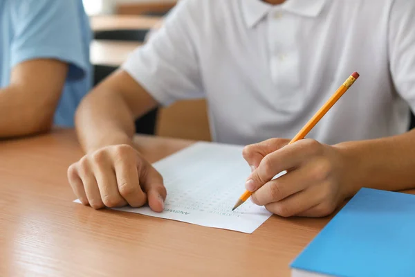 Teenage boy passing school test in classroom