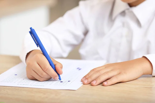 Pupil passing school test in classroom, closeup