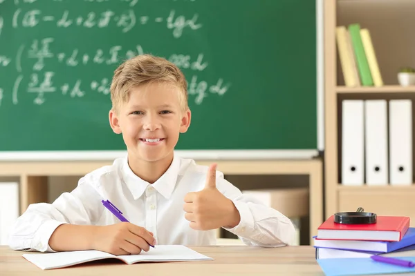 Kleine jongen doet huiswerk in het klaslokaal — Stockfoto