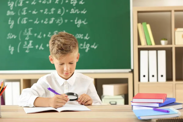 Kleiner Junge macht Hausaufgaben im Klassenzimmer — Stockfoto