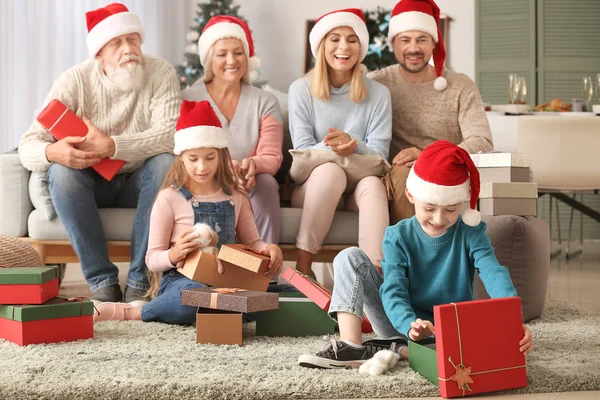 Aileleri ile küçük çocuklar evde Noel hediyeleri açılış — Stok fotoğraf