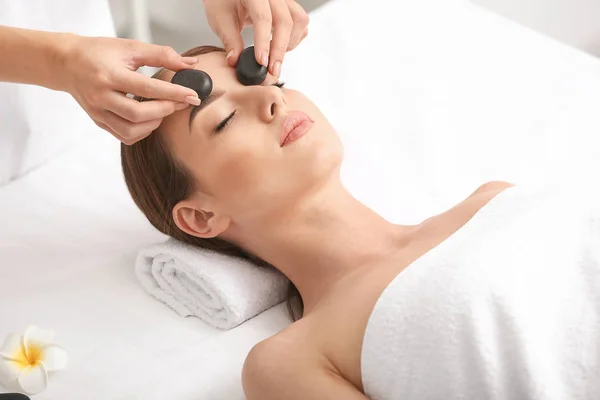Jonge vrouw het hebben van facial massage in schoonheid salon — Stockfoto