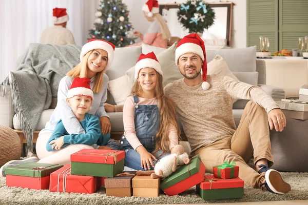 Familia feliz con cajas de regalo en la habitación decorada para Navidad — Foto de Stock