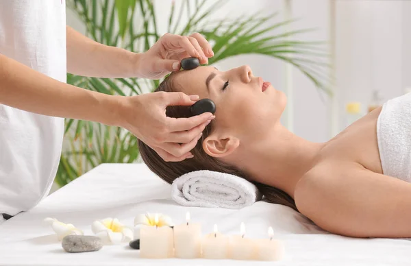 Mujer joven teniendo masaje facial en salón de belleza — Foto de Stock