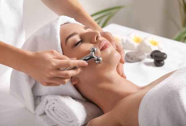 Jonge vrouw het hebben van facial massage in schoonheid salon — Stockfoto