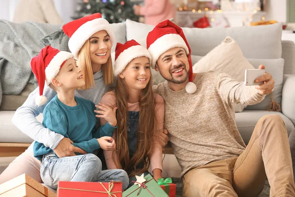 Família feliz com presentes de Natal levando selfie em casa — Fotografia de Stock
