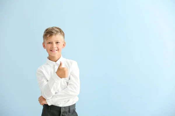 Little schoolboy showing thumb-up on color background — Stock Photo, Image