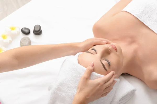 Jonge vrouw het hebben van facial massage in schoonheid salon — Stockfoto