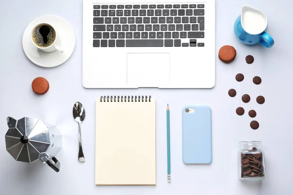 Ordenador portátil con teléfono móvil, notebook, dulces, café y leche sobre fondo blanco —  Fotos de Stock