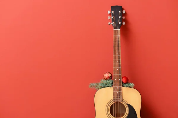 色の背景にクリスマスの装飾を持つギター — ストック写真