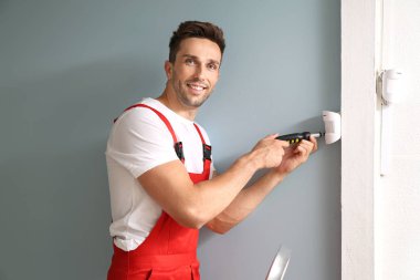 Elektrikçi, kapalı mekanlarda alarm sistemi kurma