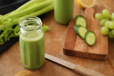 Ahşap masa üzerinde malzemelerle lezzetli smoothie Şişe