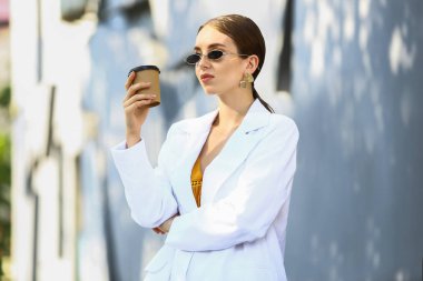 Açık havada kahve fincanı ile şık genç kadın