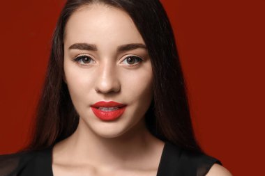 Renk arka planında parlak ruj olan güzel genç bir kadın.