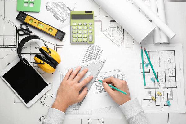 Male architect working at table, top view