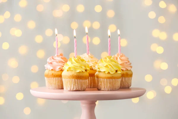Tasty Birthday cupcakes on stand against defocused lights — Stock Photo, Image