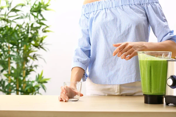 Young woman preparing healthy smoothie in kitchen — Stock Photo, Image
