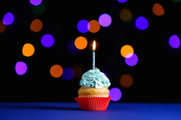 Смачний кекс до дня народження на столі проти розфокусованих вогнів — стокове фото