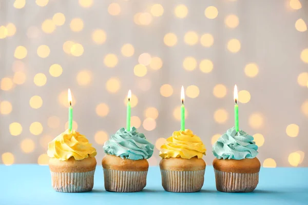 Tasty Birthday cupcakes on table against defocused lights — Stock Photo, Image