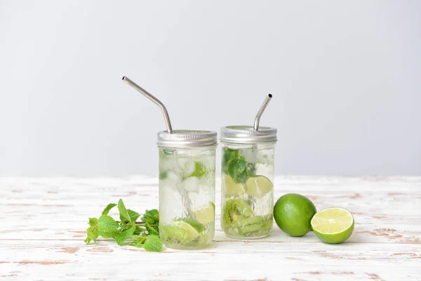 Jars of fresh infused water on white wooden table — Stock Photo, Image