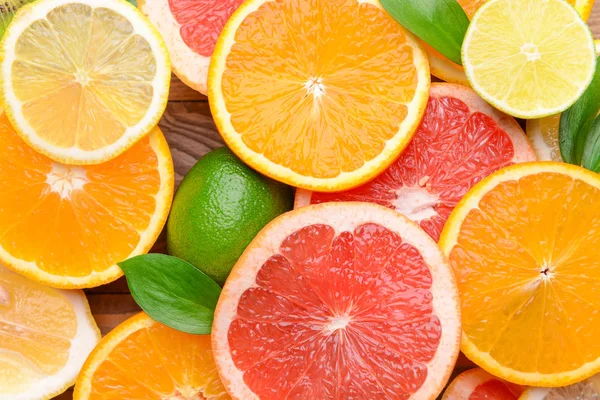Verschillende citrusvruchten op houten achtergrond, close-up — Stockfoto