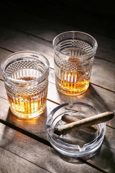 木製のテーブルの上に葉巻と冷たいウイスキーのグラス — ストック写真