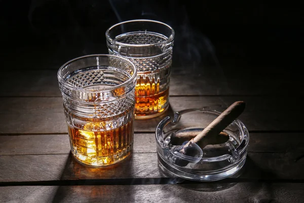 Glasses of cold whiskey with cigars on wooden table — Stock Photo, Image