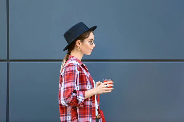 Stylish young woman with cup of coffee outdoors — Stock Photo, Image