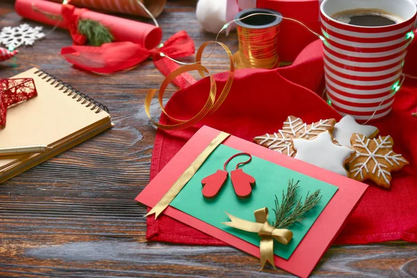 Рождественская открытка ручной работы с печеньем и кофе на деревянном столе — стоковое фото