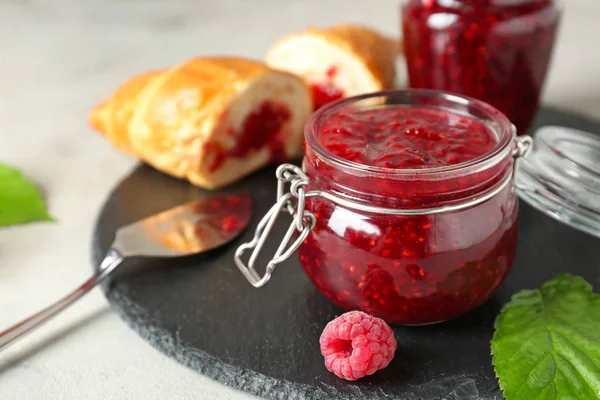 Tasty raspberry jam with croissants on table — Stock Photo, Image