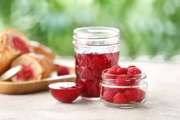Вкусное малиновое варенье с ягодами на столе — стоковое фото