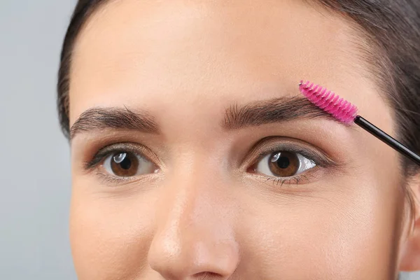 Mulher jovem submetida a procedimento de correção de sobrancelha, close-up — Fotografia de Stock