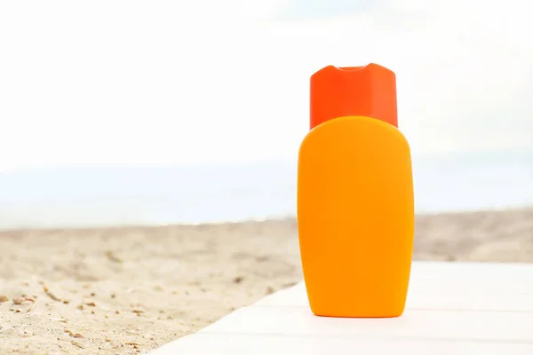 Bouteille de crème solaire sur la plage de sable — Photo
