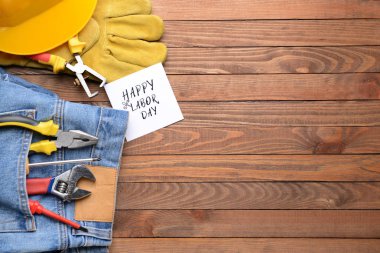 Ahşap arka plan üzerinde alet ve kart seti ile Jeans. İşçi Bayramı kutlaması