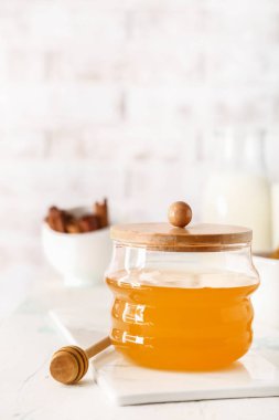 Beyaz masada lezzetli bal ile Kavanoz