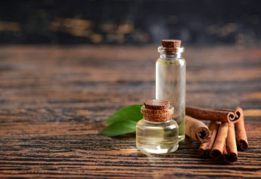 Ahşap masa üzerinde Aromatik tarçın çubukları ve yağ