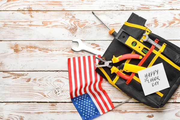 Set of tools, card with text HAPPY LABOR DAY and USA flag on wooden background