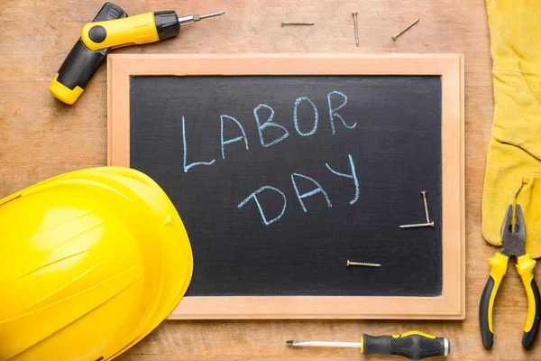 Conjunto de herramientas y pizarra con texto LABOR DAY sobre fondo de madera — Foto de Stock