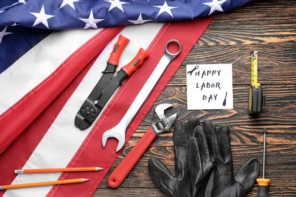 Set of tools, card with text LABOR DAY and USA flag on wooden background