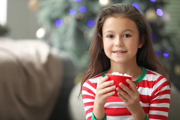 Menina bebendo chocolate quente em casa na véspera de Natal — Fotografia de Stock