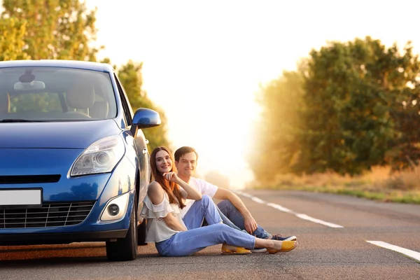 Kırsal yolda oturan yeni araba yakınında Mutlu çift — Stok fotoğraf