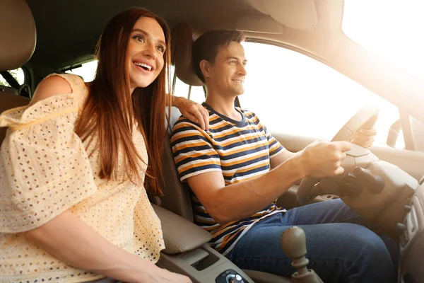 Happy couple sitting in their new car — Stock Photo, Image