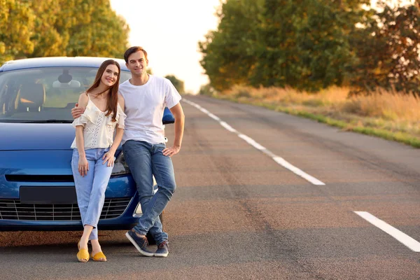 Happy couple near their new car in countryside — Stock Photo, Image