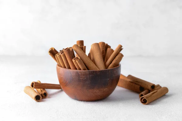 Bowl with aromatic cinnamon sticks on light background — Stock Photo, Image