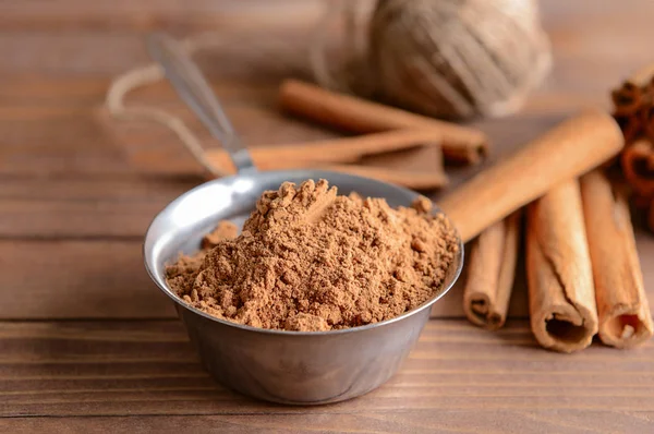 Aromatic cinnamon sticks and powder on wooden table — Stock Photo, Image