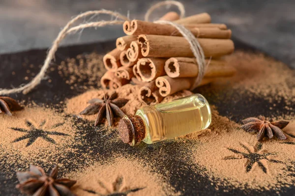 Cinnamon essential oil, powder and sticks on table — Stock Photo, Image