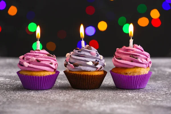 Välsmakande födelsedag cupcakes på bordet mot defokuserad ljus — Stockfoto