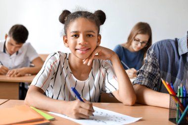 Afro-Amerikalı genç kız sınıfta okul testi geçen